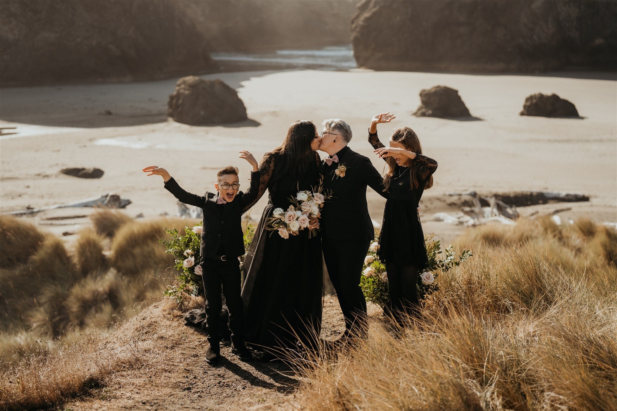 Brides kiss while children dance during Pacific Northwest elopement