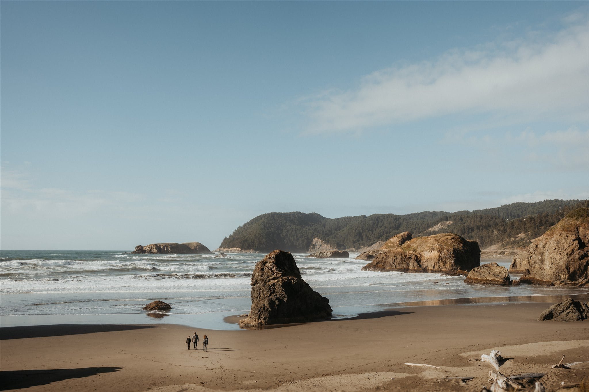 Brides walk across the beach during their Pacific Northwest elopement