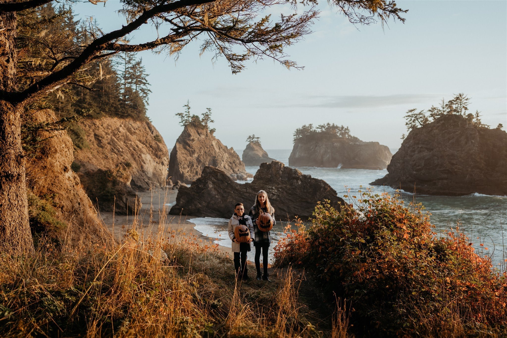 Son and daughter holding pumpkins on the Oregon Coast