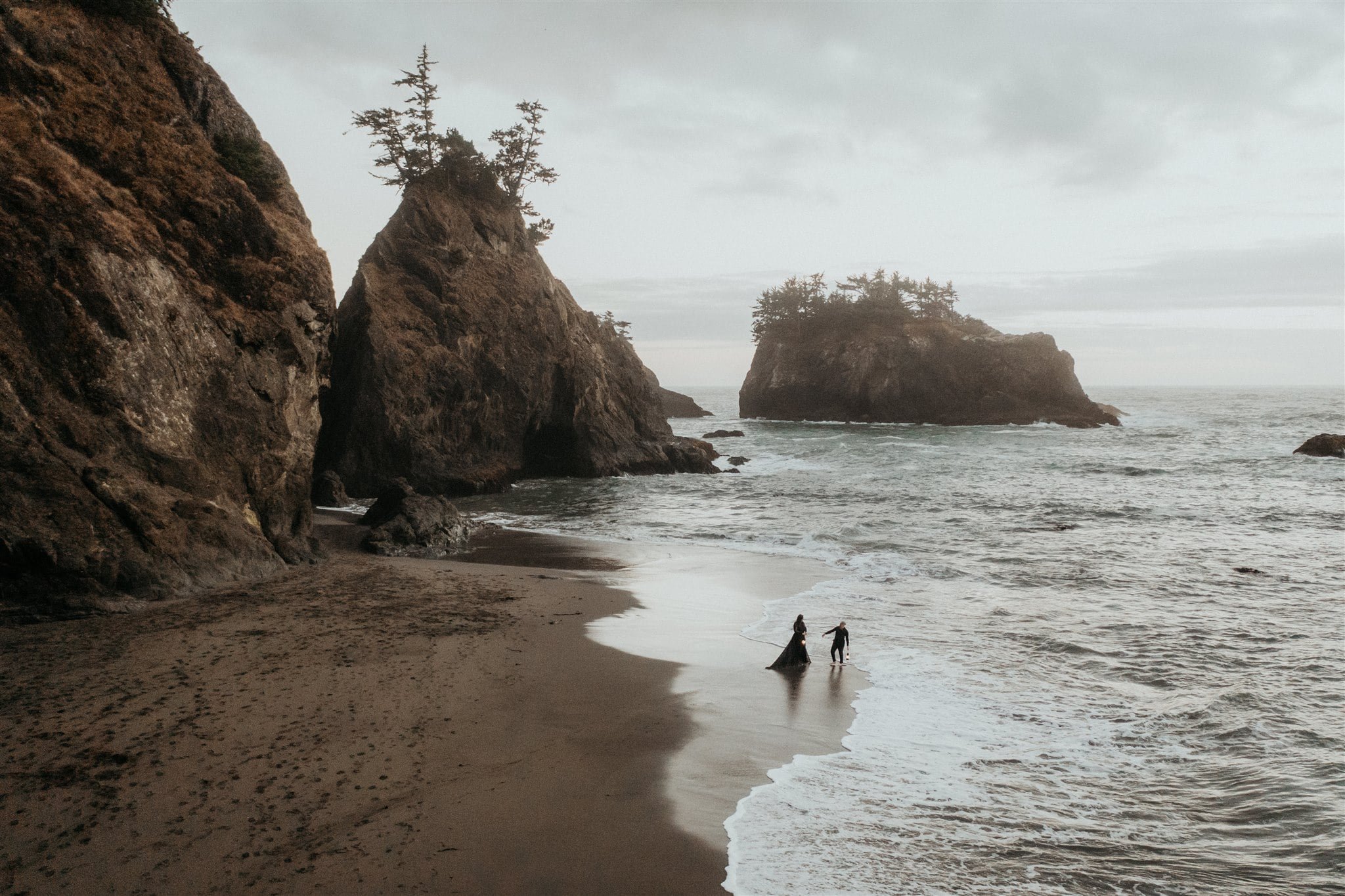 Two brides dance in the ocean during their Pacific Northwest elopement