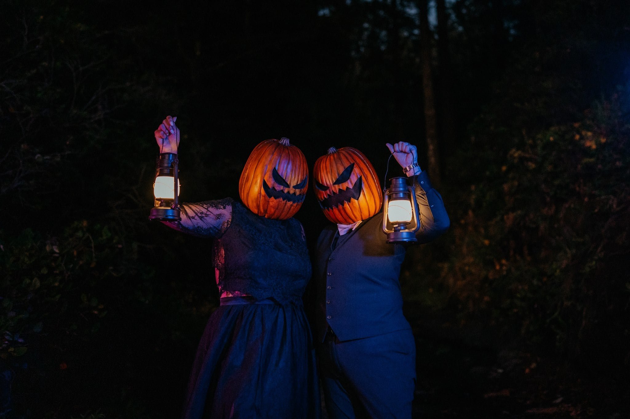 Two brides wearing all black elopement outfits and pumpkins on the heads during Pacific Northwest elopement photos
