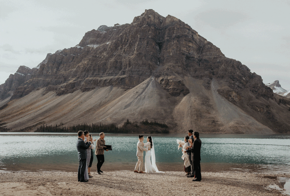 Guests clap while bride and groom kiss at Banff National Park elopement