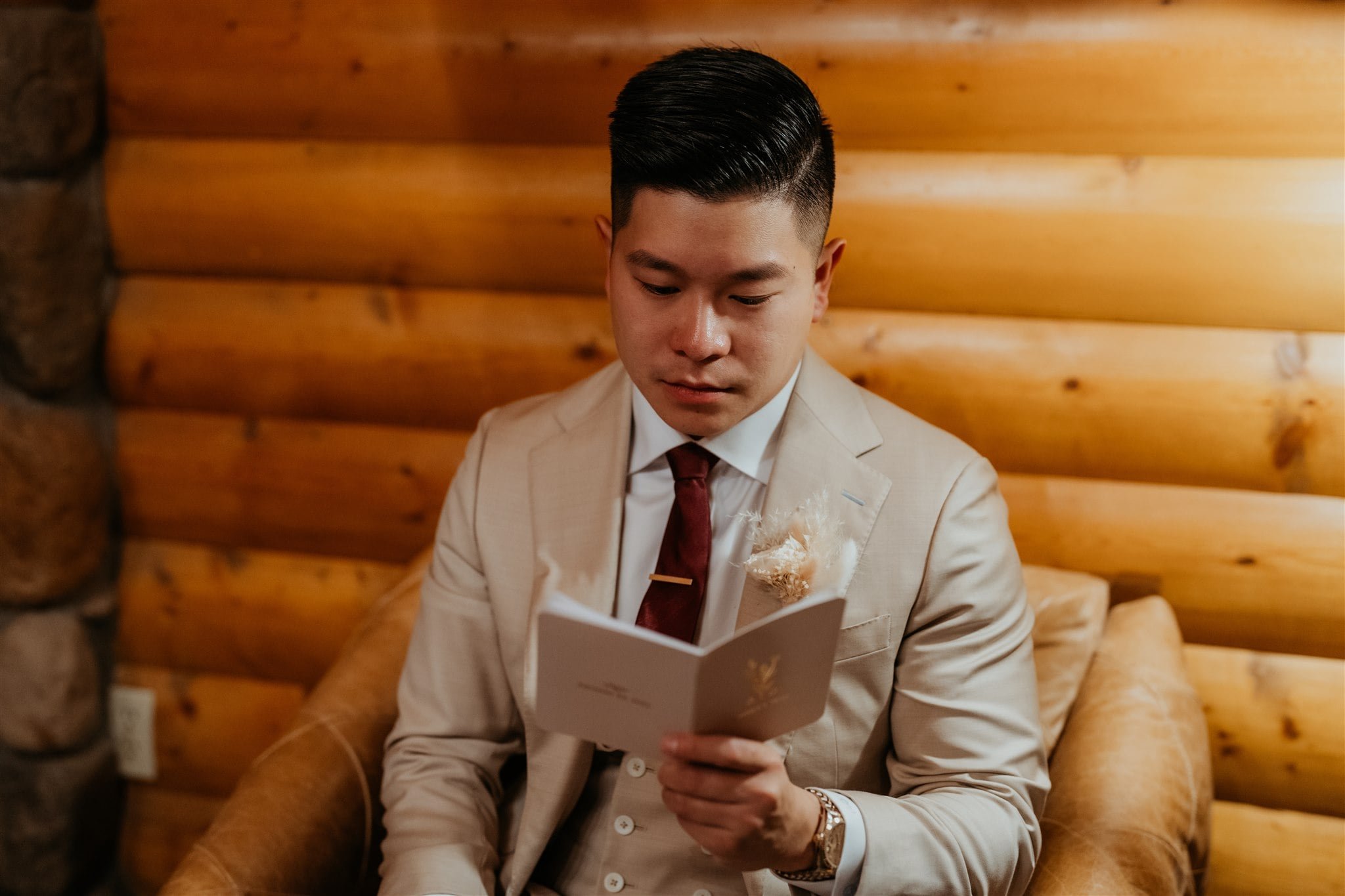 Groom reading vows from vow book before adventure elopement in Banff