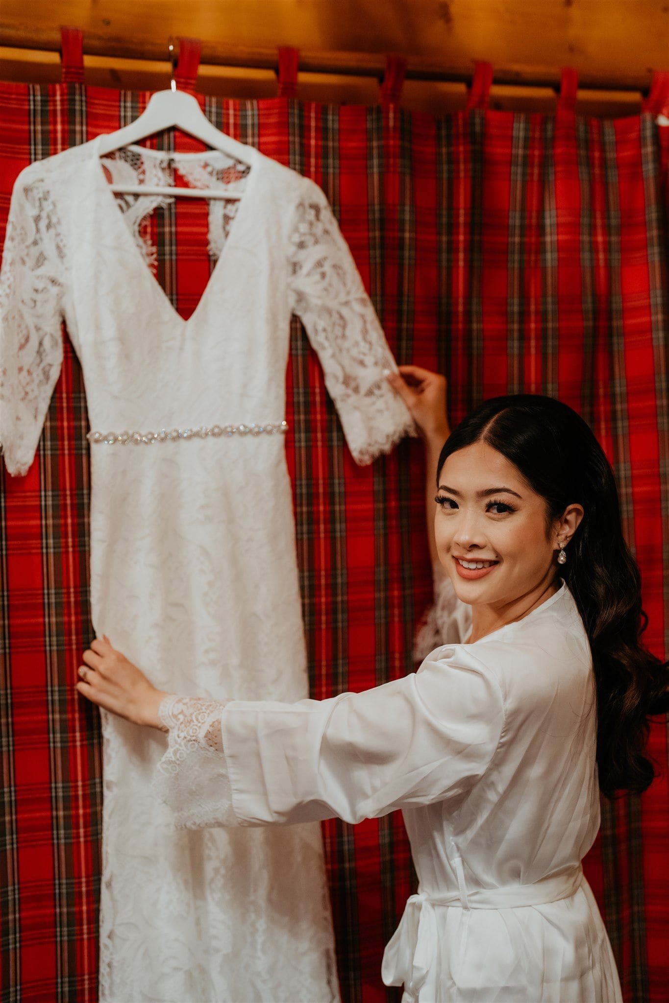 Bride adjusting white wedding dress while getting ready for elopement in Banff