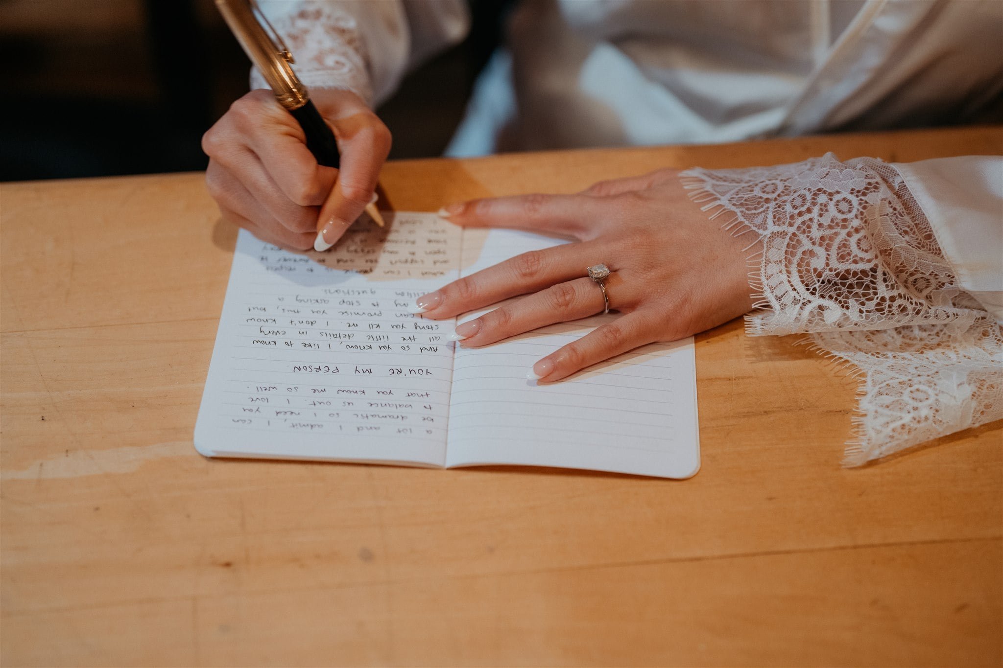 Bride writing personal vows in vowbook