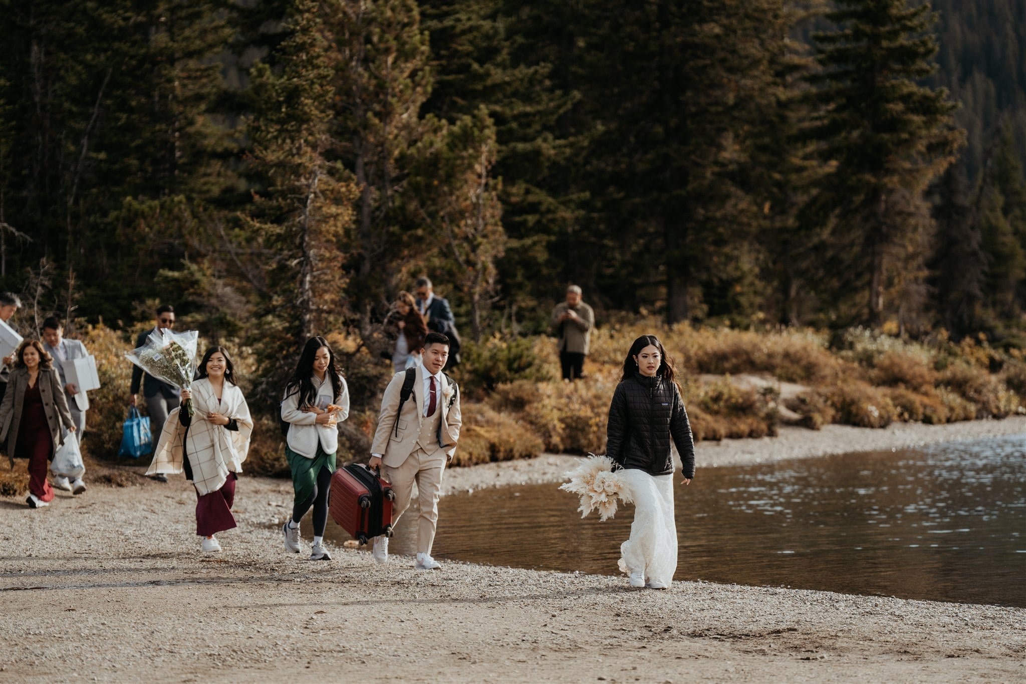 Bride and groom walk with guests to their Banff National Park elopement ceremony location