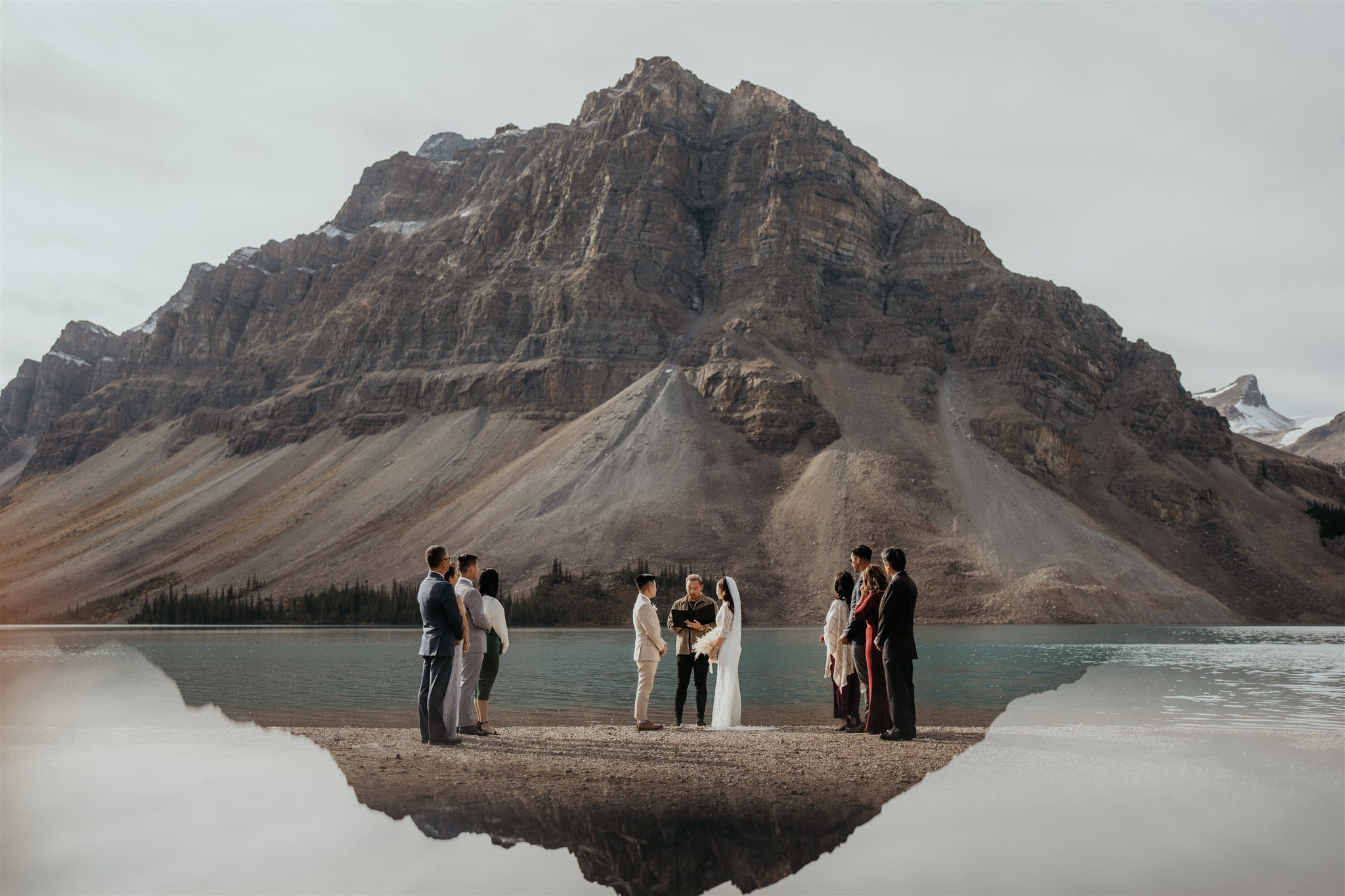 Bride and groom exchange vows at their Banff National Park elopement ceremony with guests