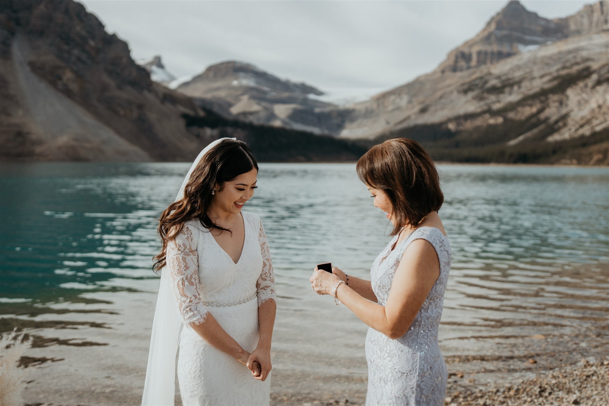 Mother of the bride gives a gift to the bride during her elopement in Banff