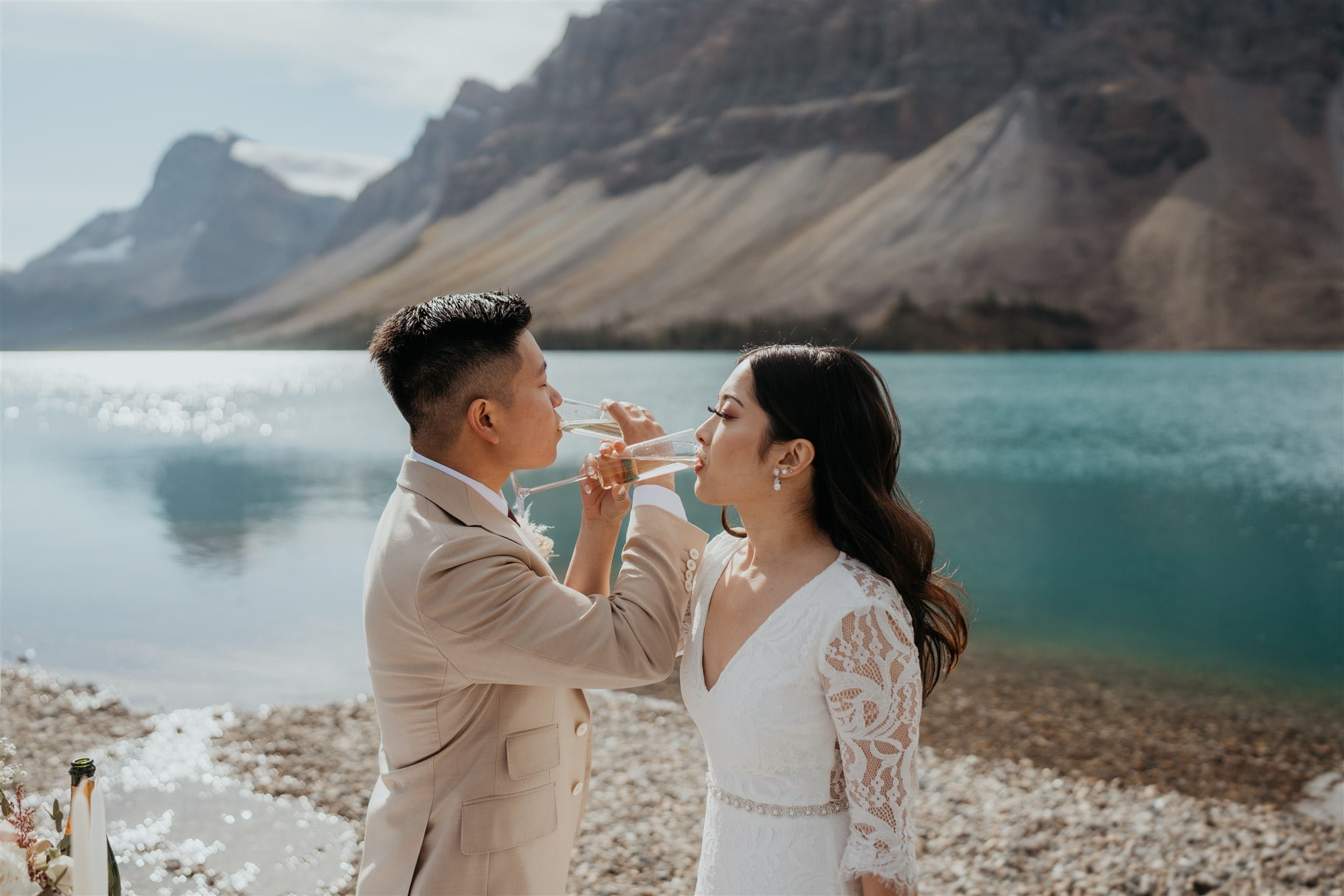 Bride and groom sip champagne during their Banff National Park elopement