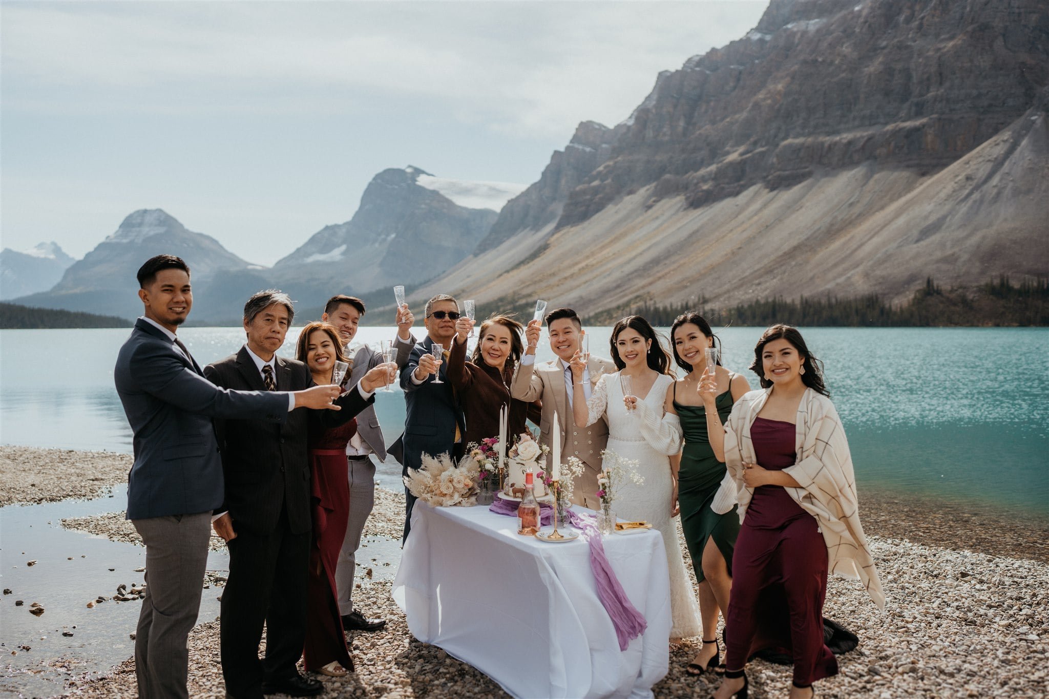 Bride and groom toast with guests at their Banff National Park elopement 