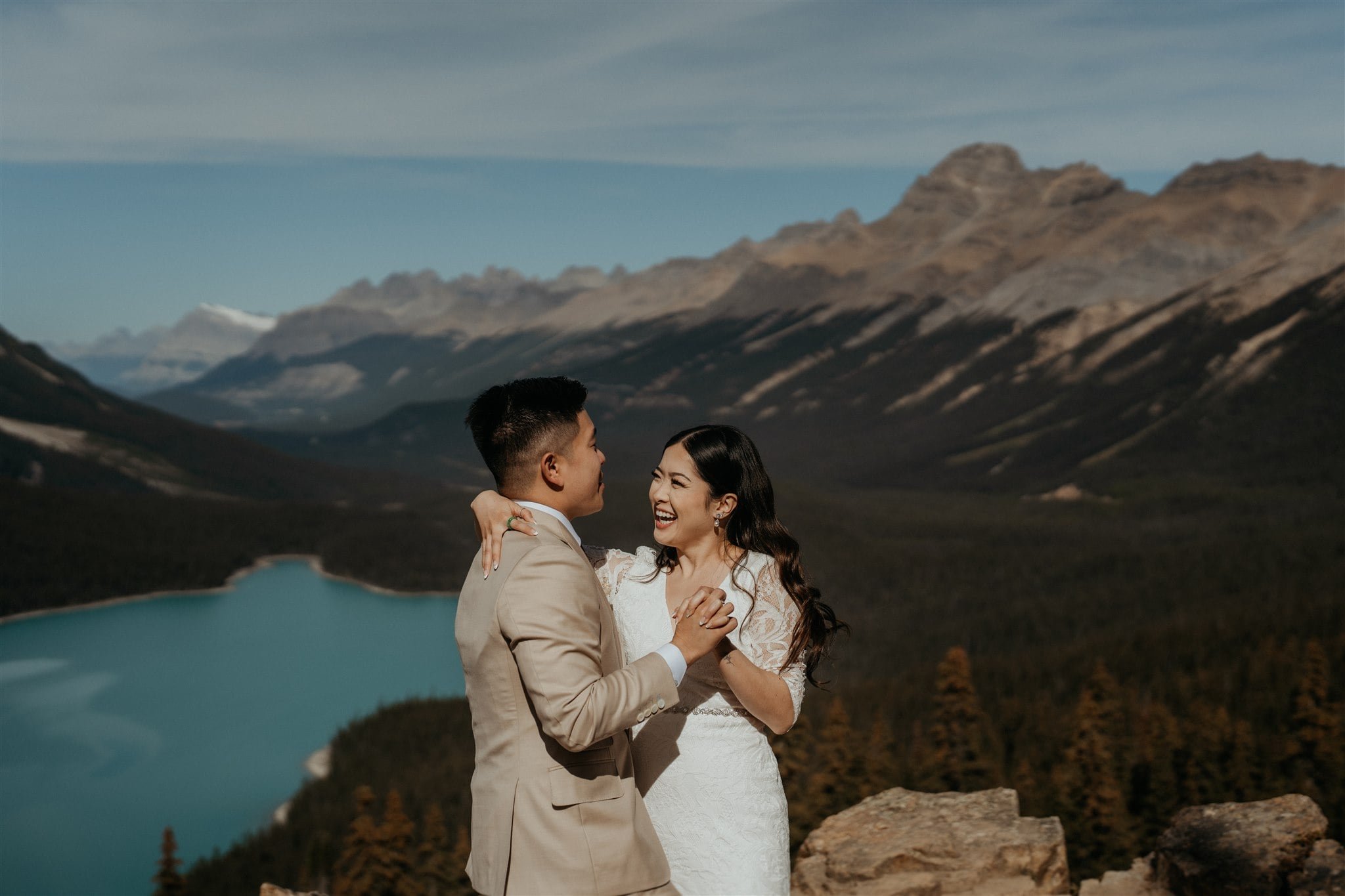 Bride and groom dance on top of a mountain looking out over a lake at their Banff National Park elopement