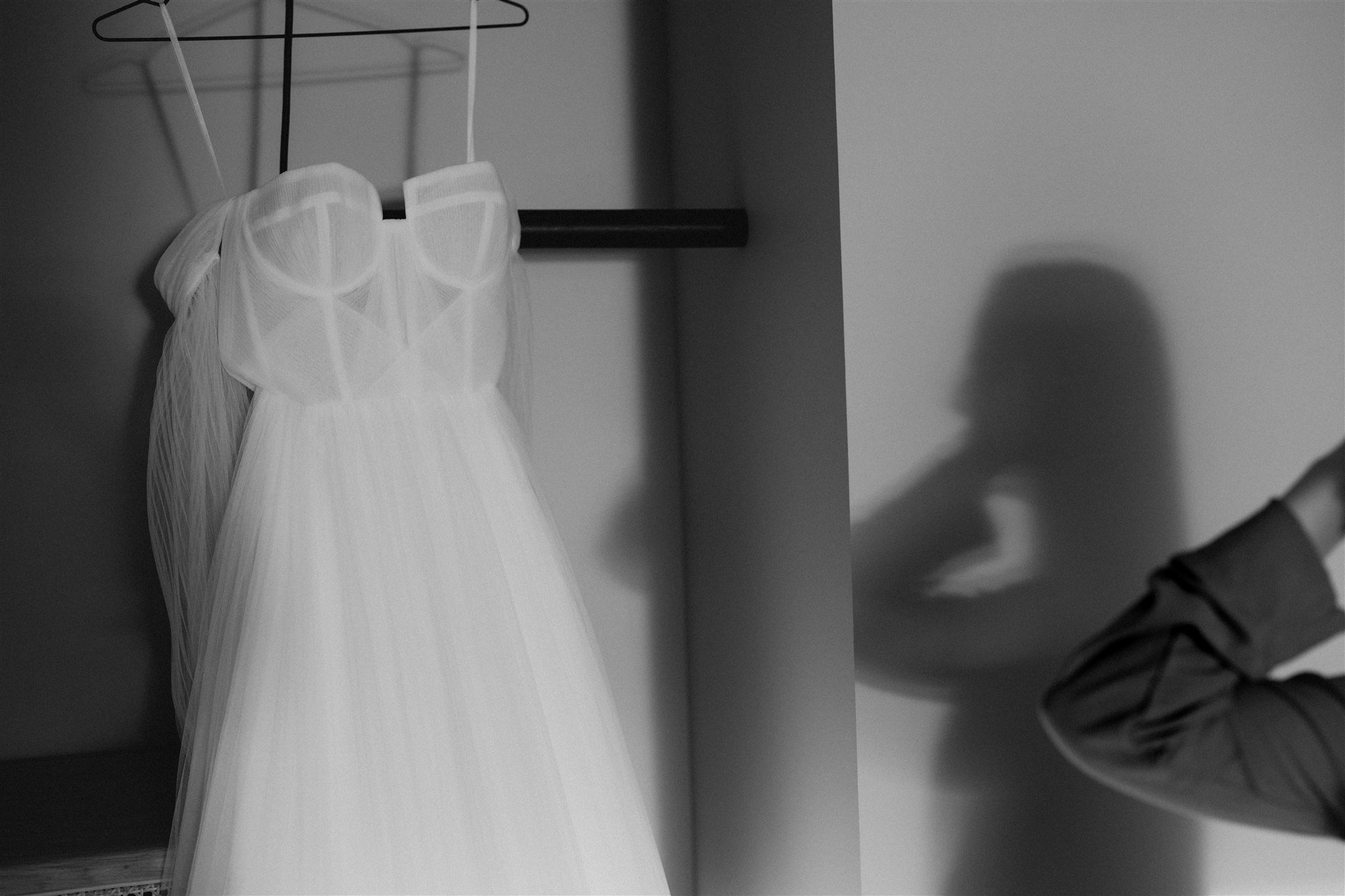 White wedding dress hanging from the bed