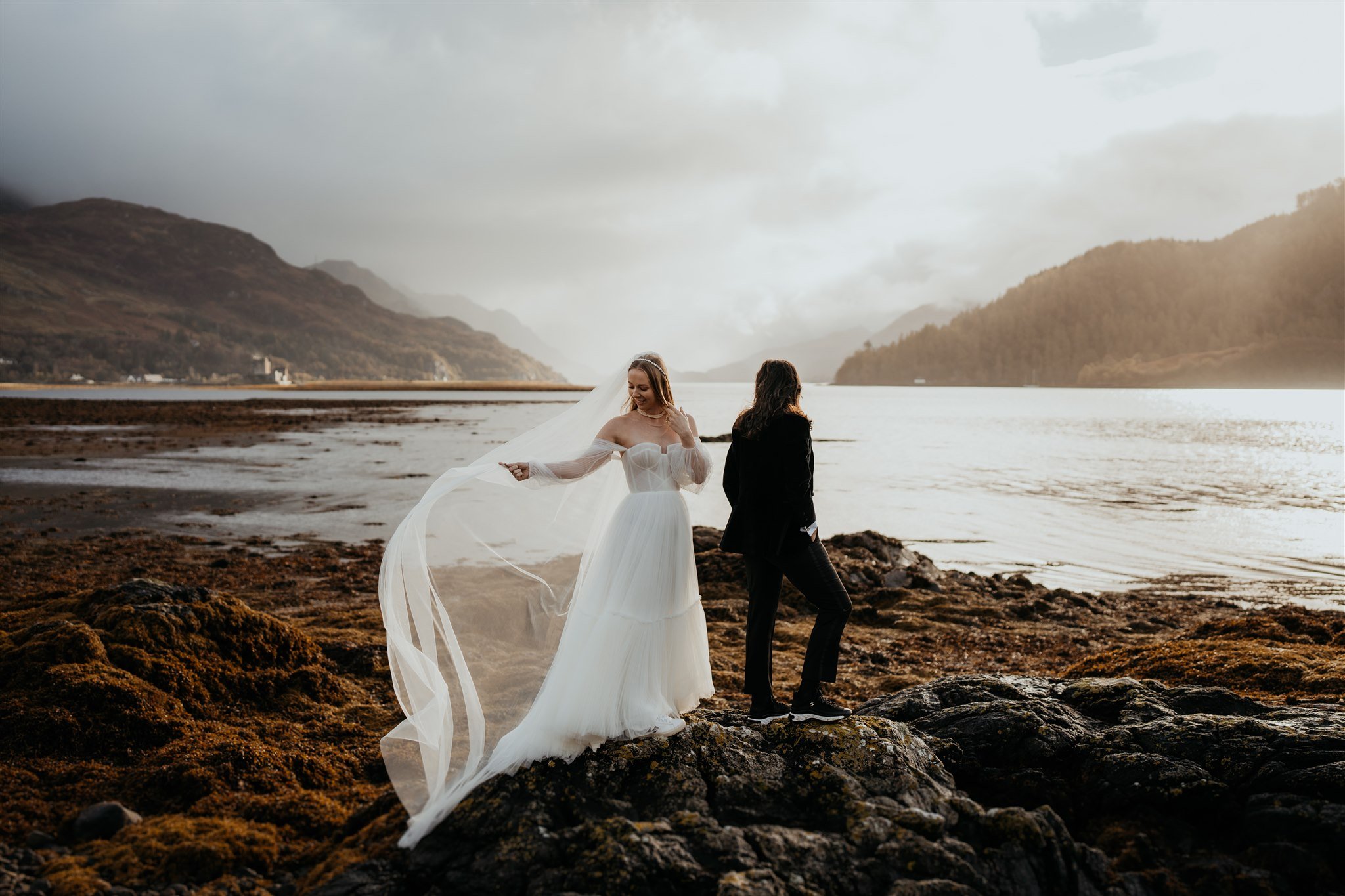Bride adjusts veil in the wind before elopement first look on the Isle of Skye