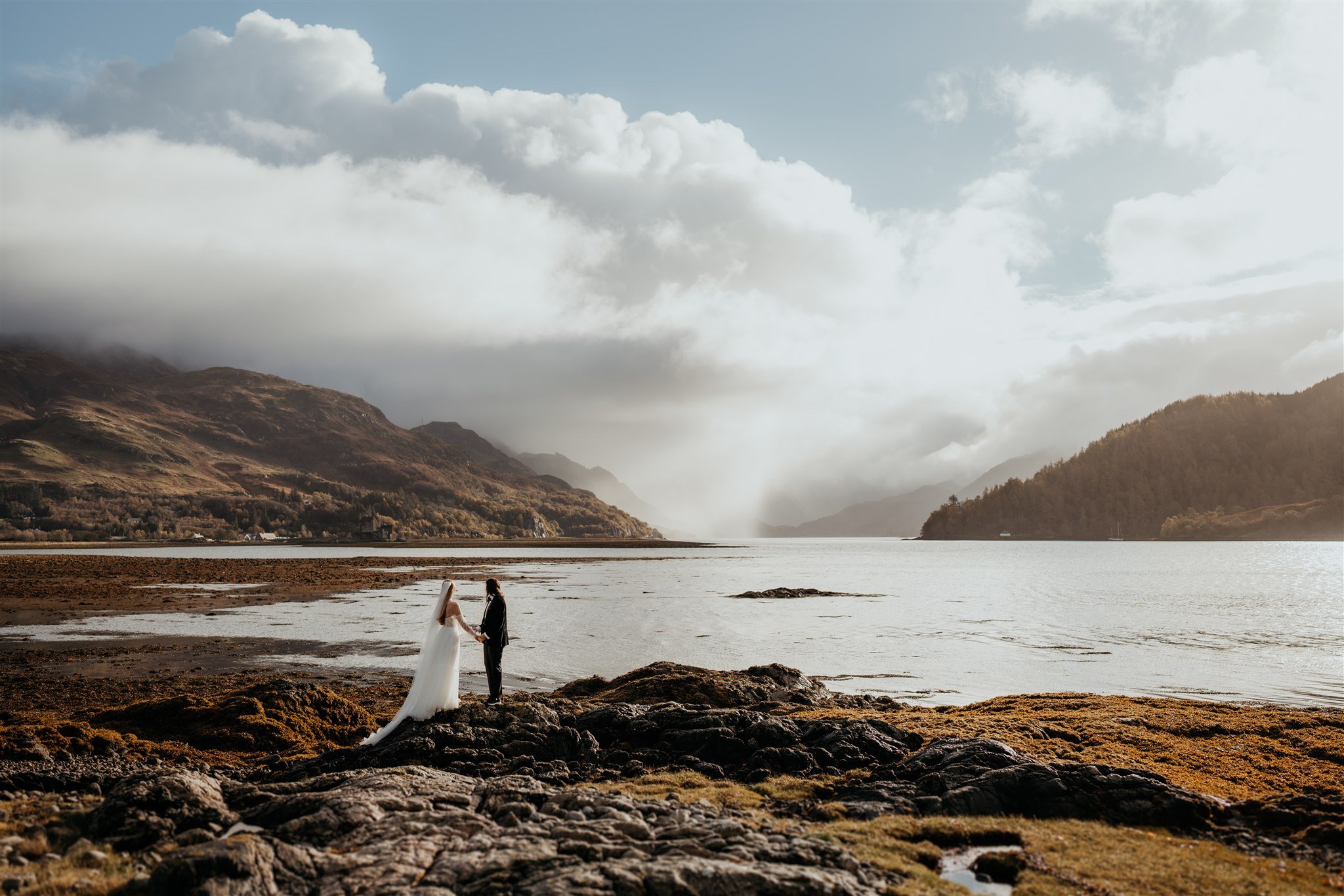 Brides hold hands after elopement first look on the Isle of Skye