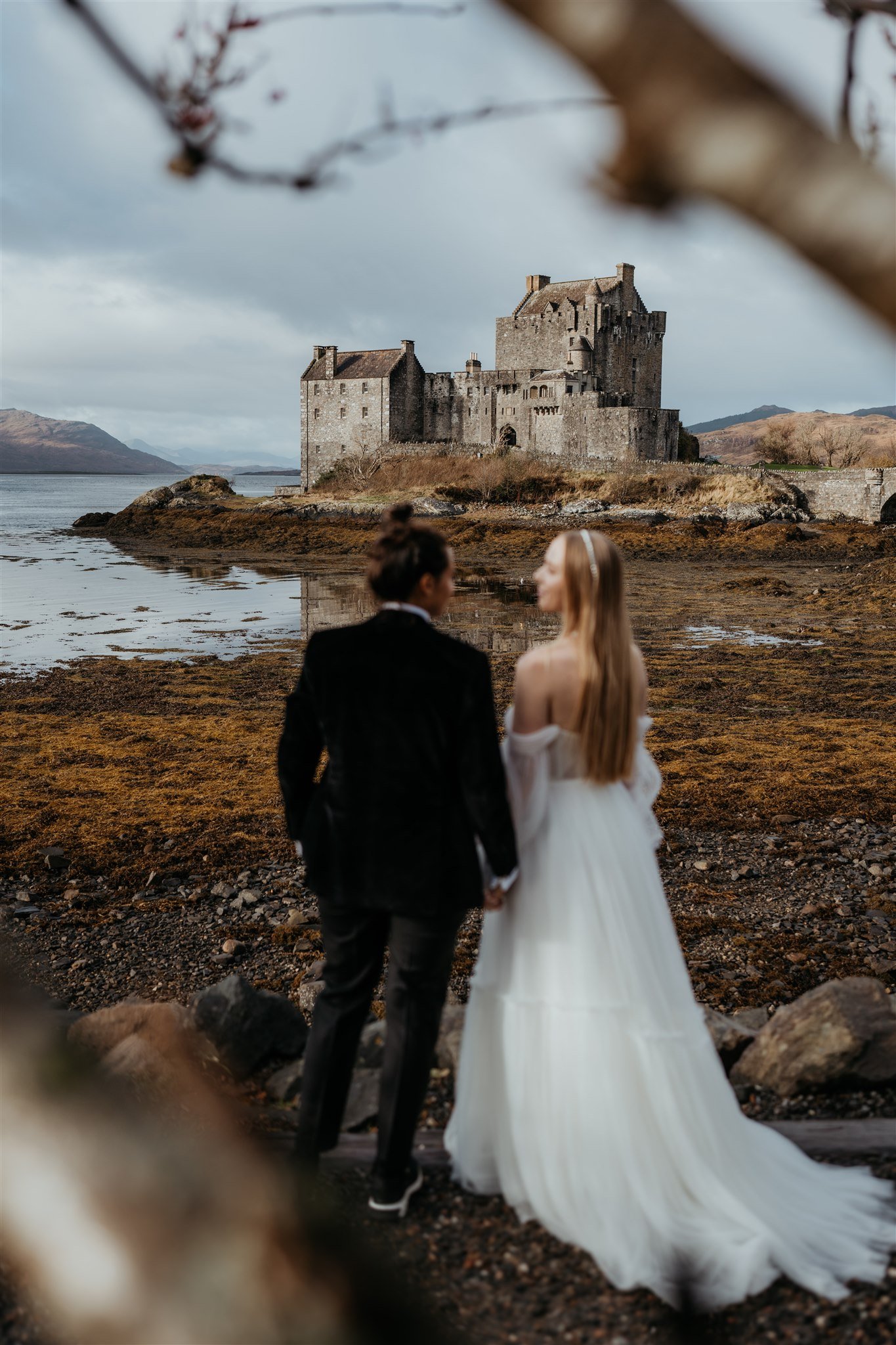 Couple elopement photos in front of a castle on the Isle of Skye in Scotland