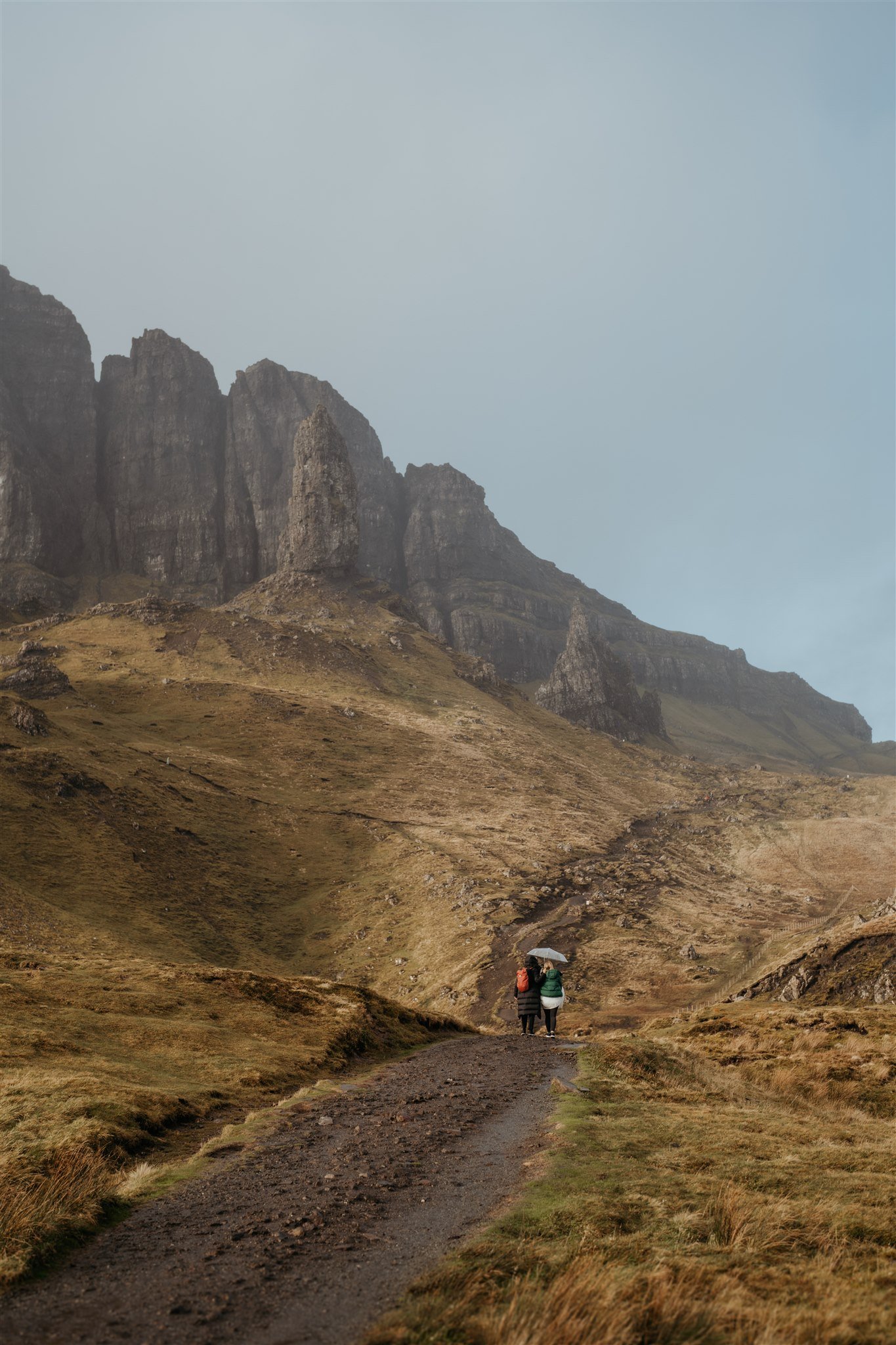Brides hike in the rain to their Isle of Skye elopement location
