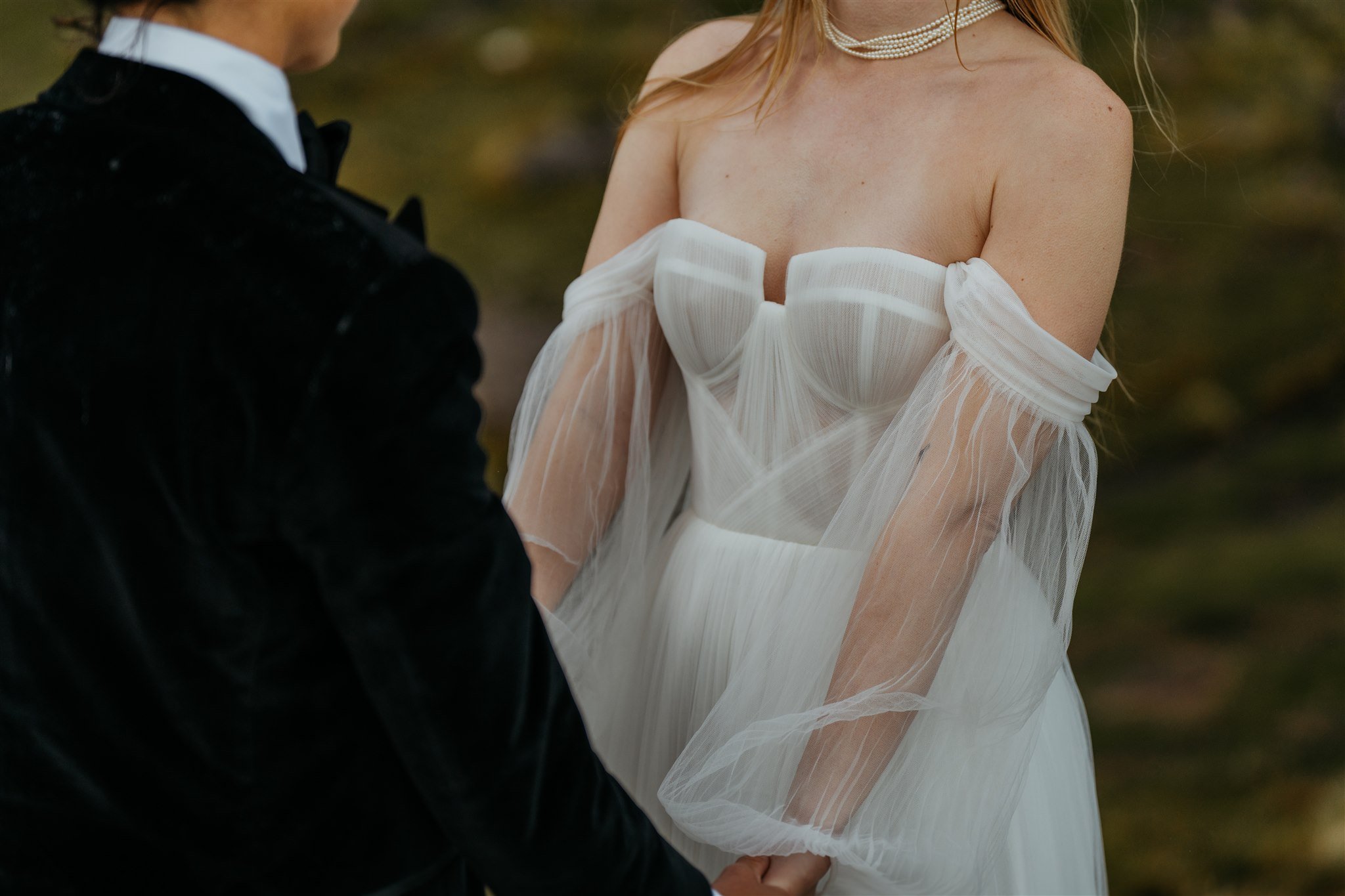 Brides hold hands during their elopement ceremony 