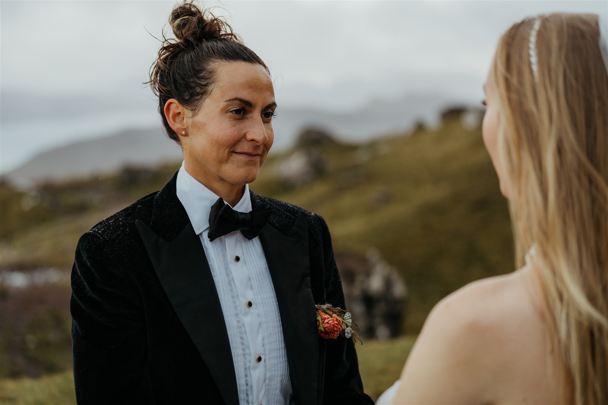 Brides hold hands while exchanging personal vows at their elopement ceremony