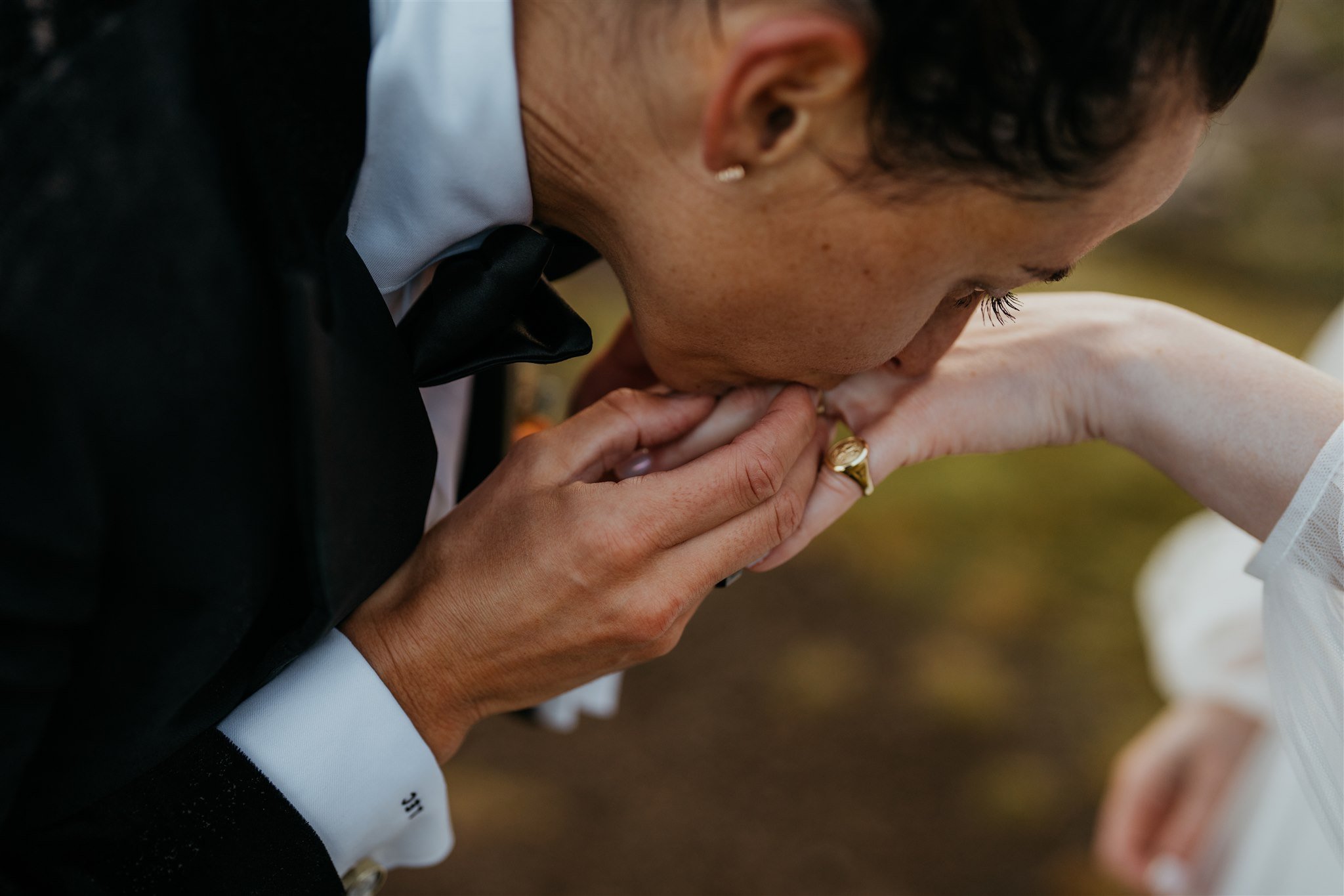 Bride kisses her wife's hand after exchanging vows at elopement in Scotland