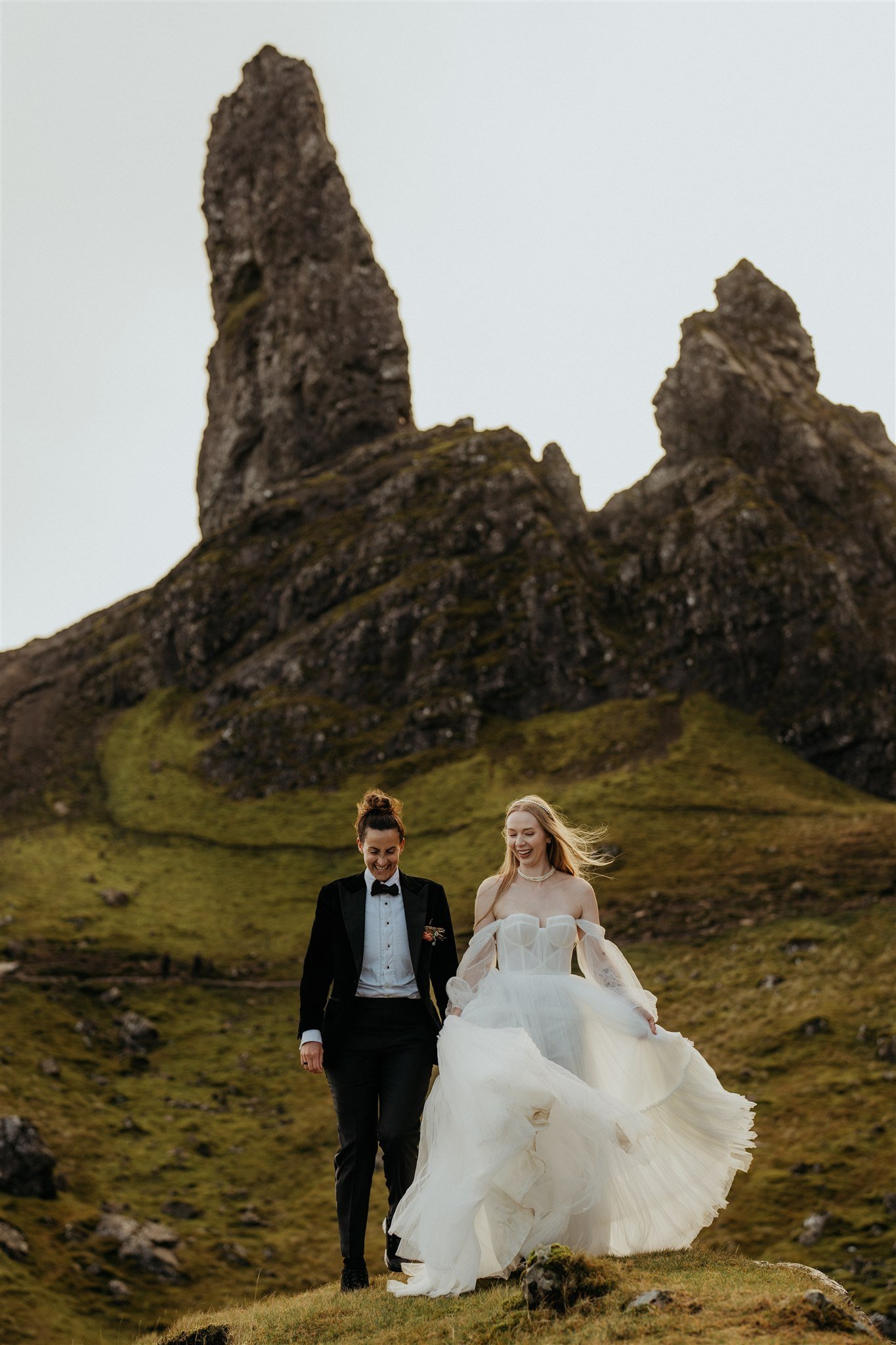Brides run through the hills during their Isle of Skye Scotland elopement