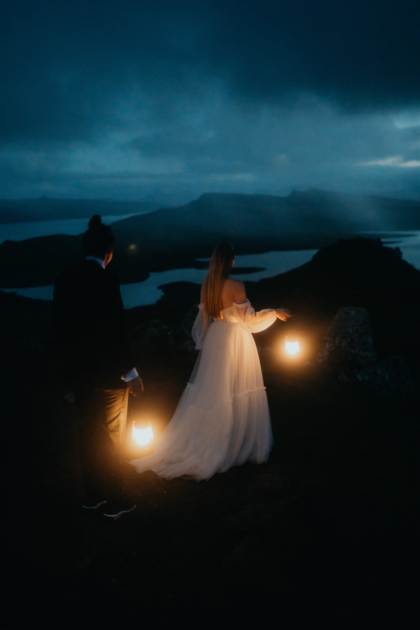 Brides holding lanterns during blue hour elopement photos on the Isle of Skye