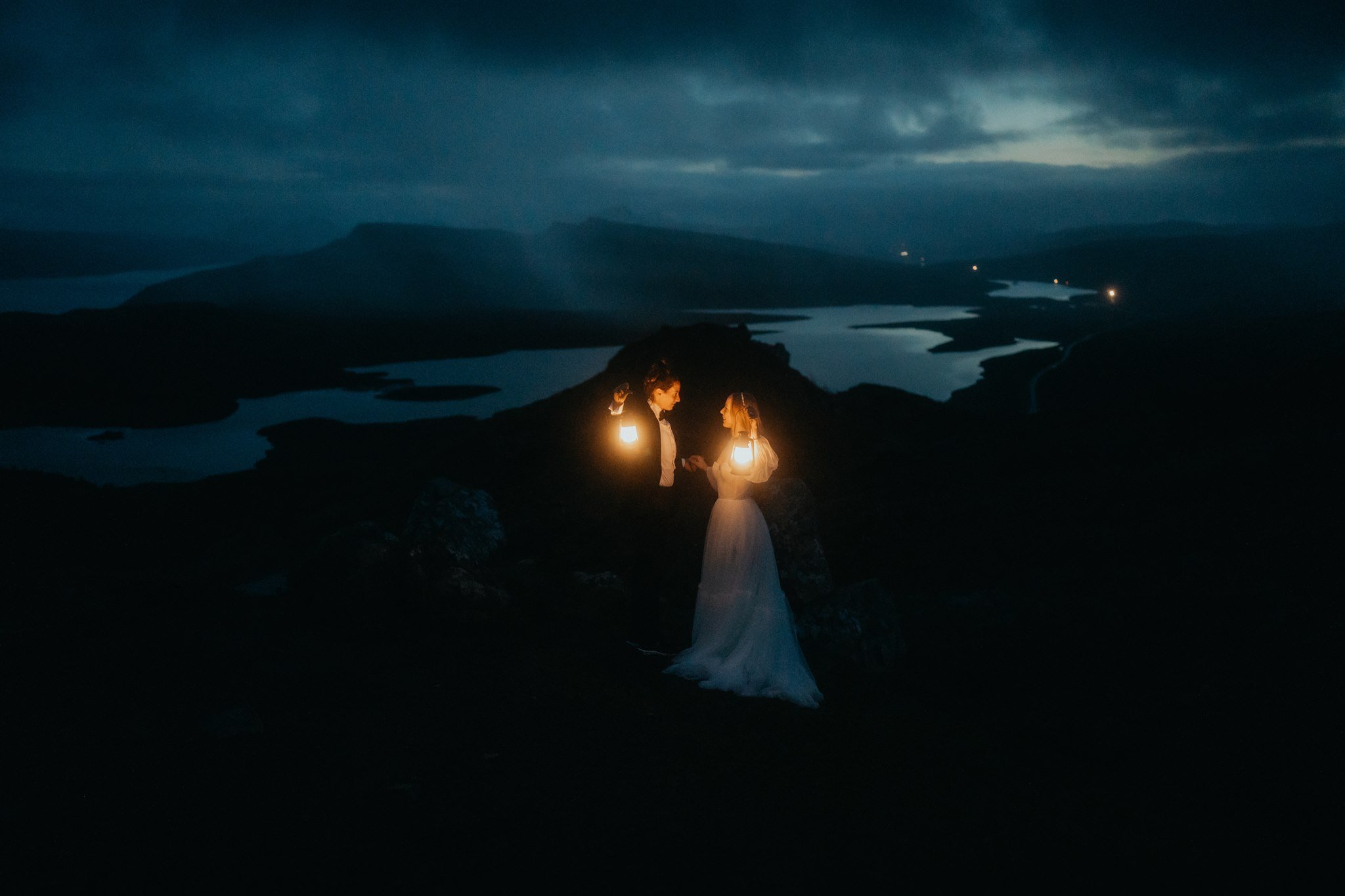 Brides holding lanterns during blue hour elopement photos on the Isle of Skye