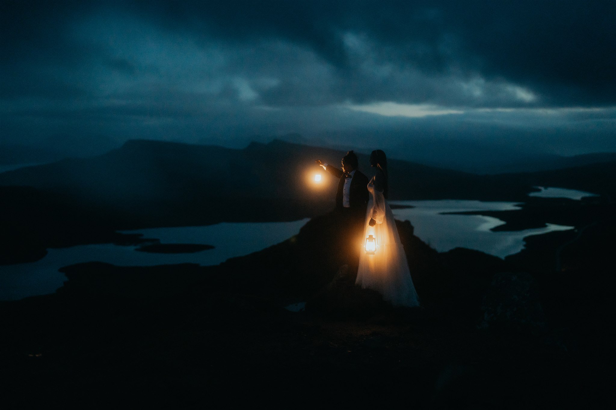 Brides holding lanterns during blue hour elopement photos on the Isle of Skye