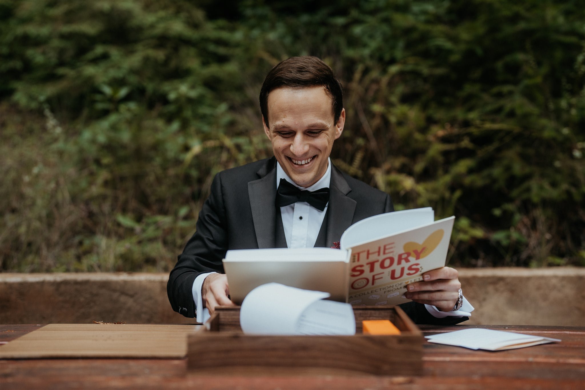 Groom smiling while reading gifted book from bride