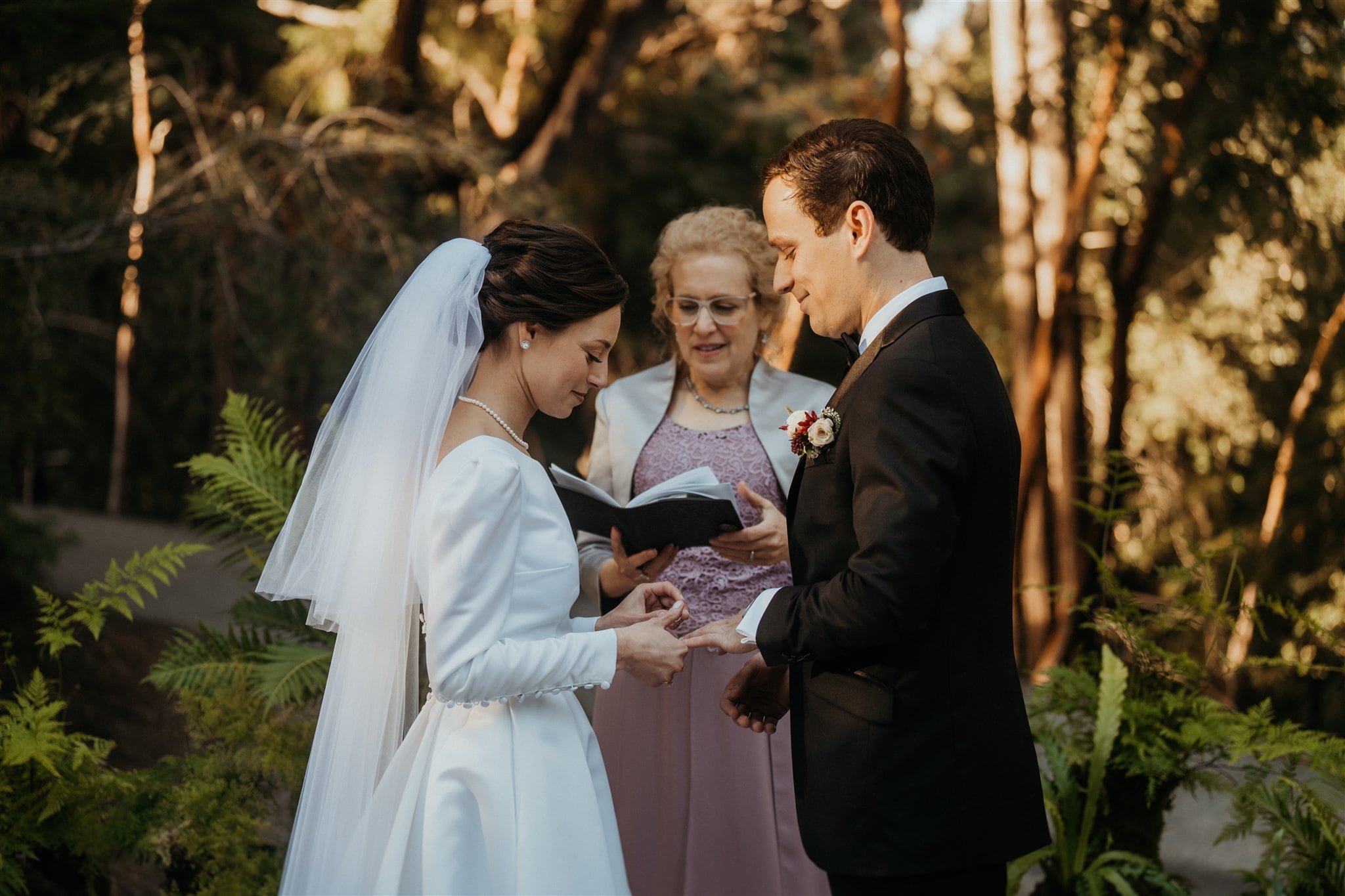 Bride and groom exchange rings at California micro wedding ceremony in the forest