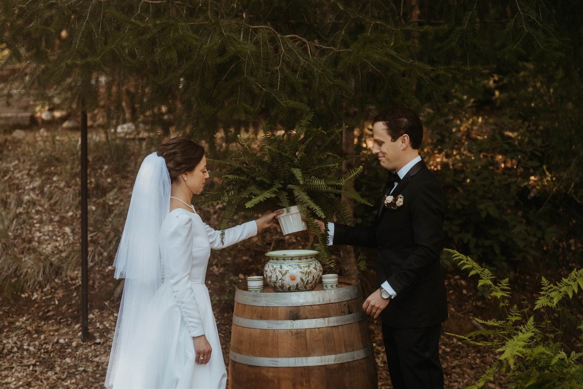 Bride and groom plant a fern at their winter wedding ceremony at Sequoia Retreat Center