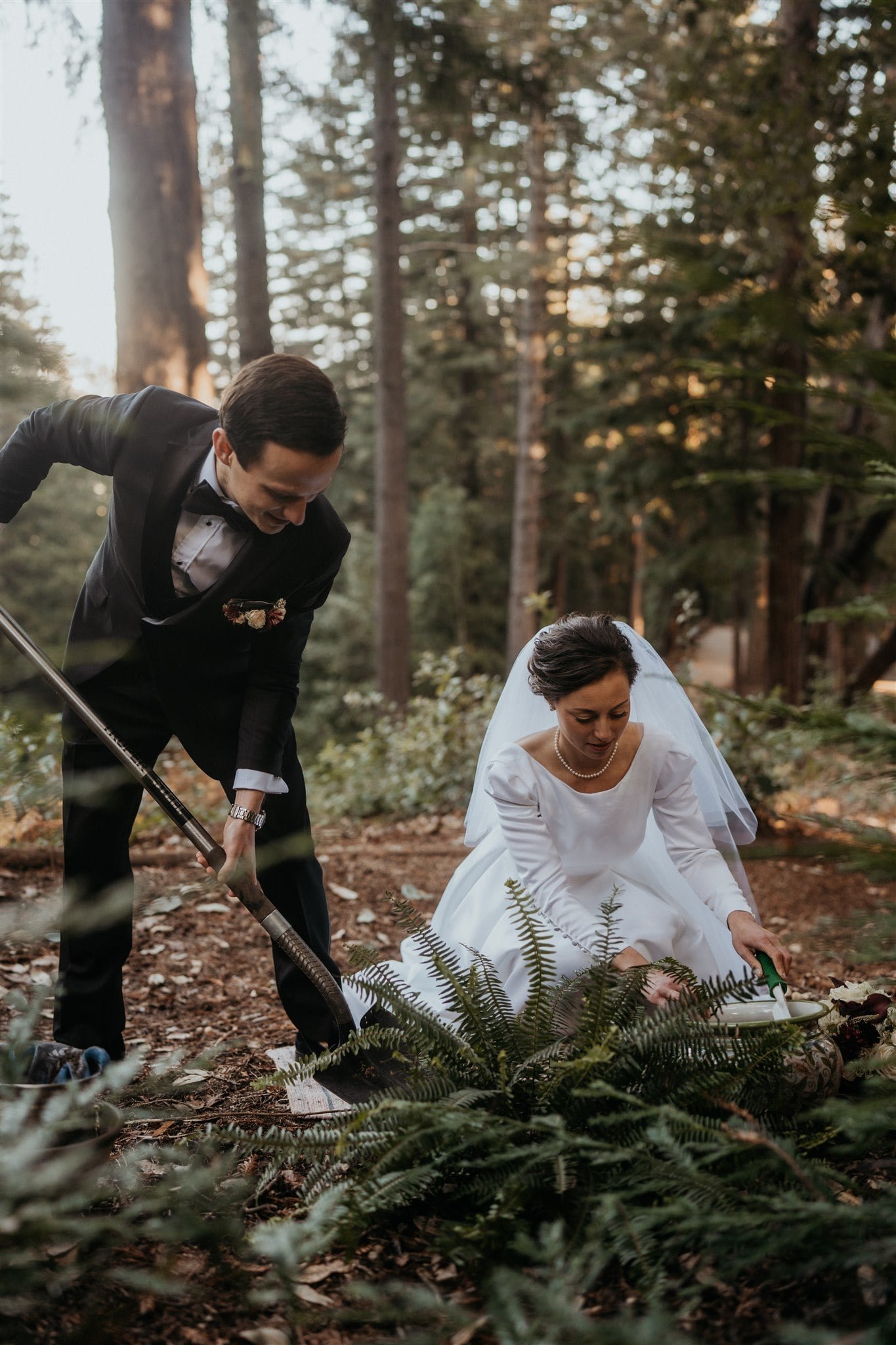 Bride and groom plant fern in the forest after their winter wedding ceremony at Sequoia Retreat Center