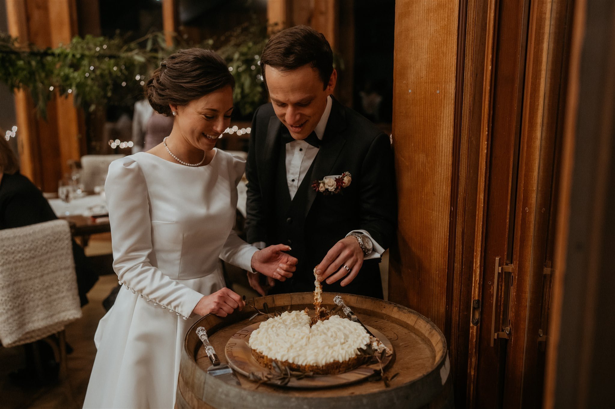 Bride and groom cut cake during winter wedding reception at Sequoia Retreat Center