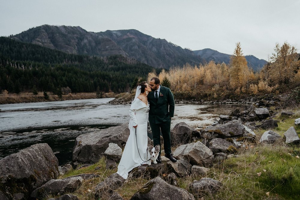 Bride and groom kiss by the river at their Columbia River Gorge elopement