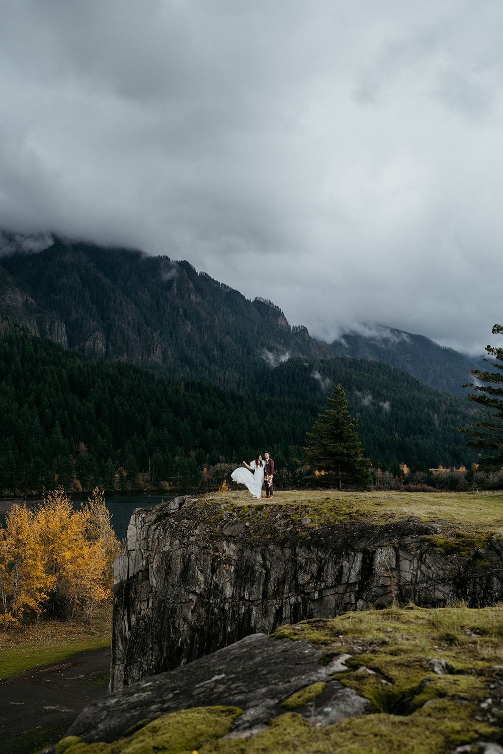 Bride and groom stand on the end of a cliff at the Columbia River Gorge
