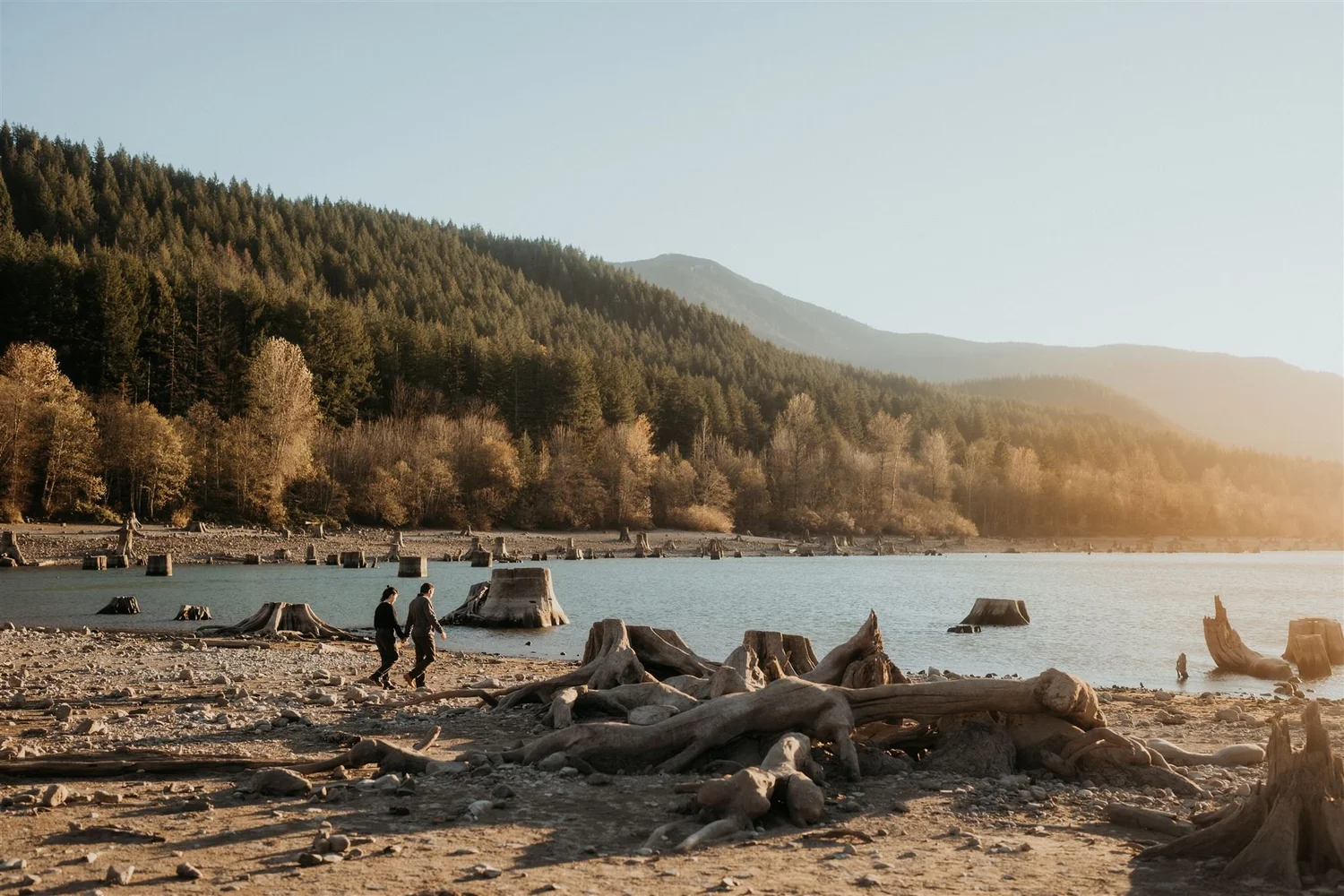 Couple holds hands while walking around the lake during their Washington elopement in Snoqualmie Valley