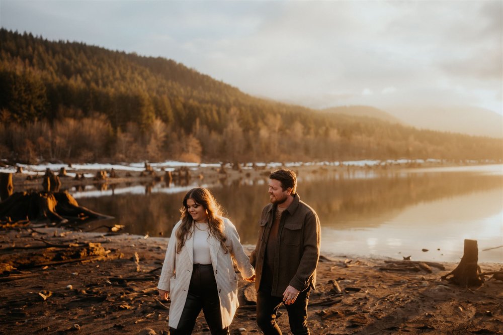 Couple holds hands while walking around the lake in Snoqualmie Valley