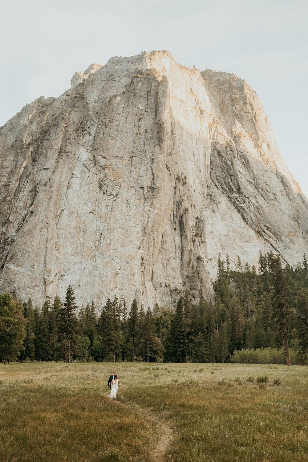 Bride and groom walk through a trail during their Yosemite elopement in El Capitan meadow