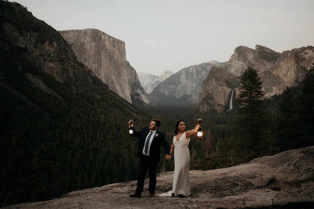 Bride and groom hold lanterns during their Tunnel View elopement in Yosemite