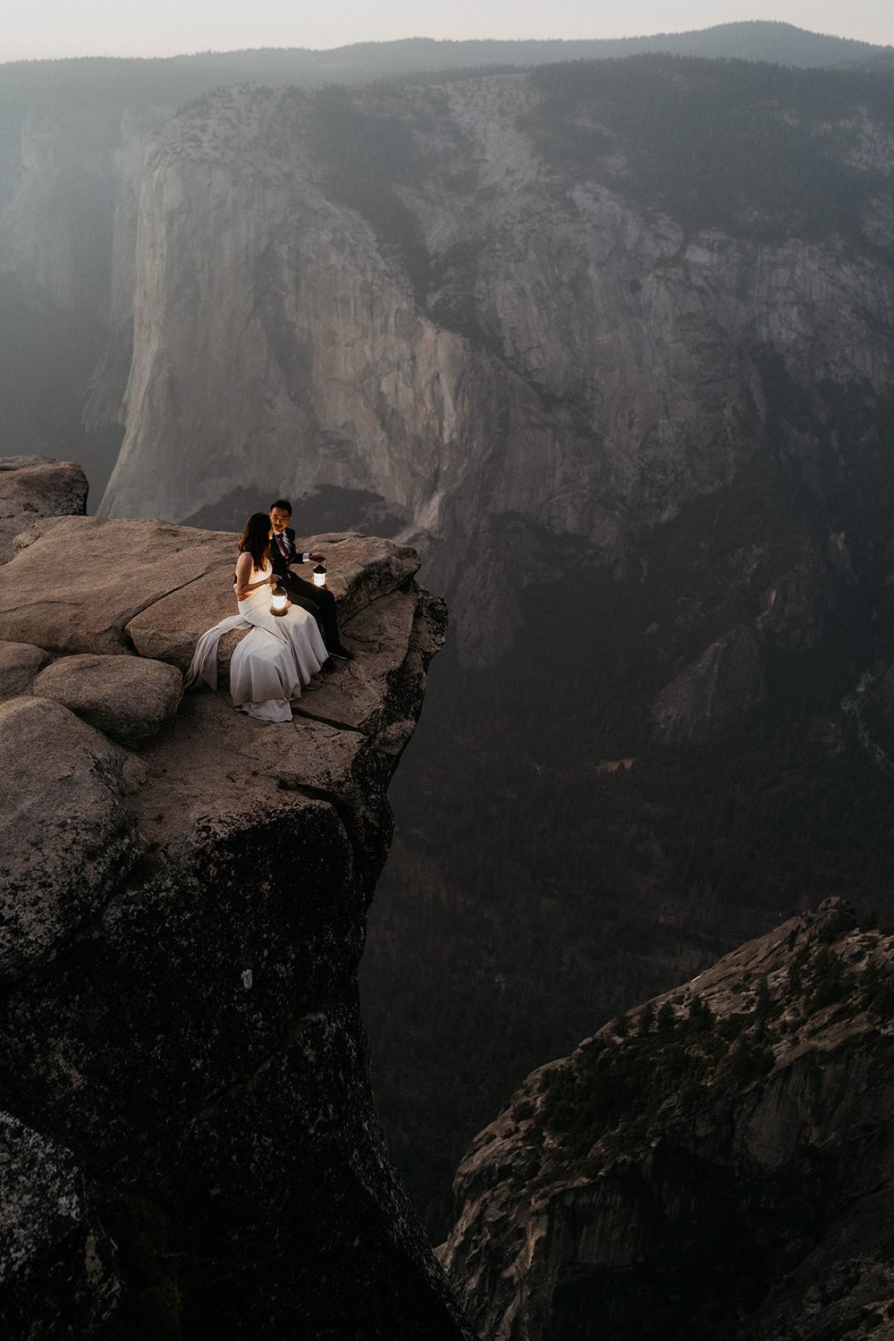 Bride and groom sit on a ledge during their Taft Point Yosemite elopement