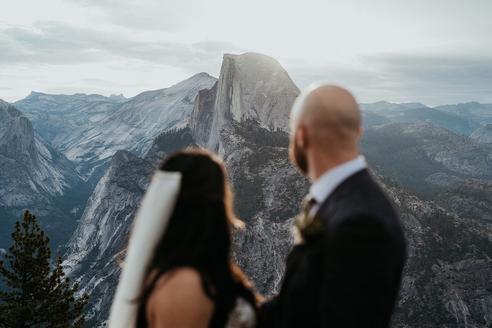 Bride and groom look out at the mountains during their Glacier Point elopement