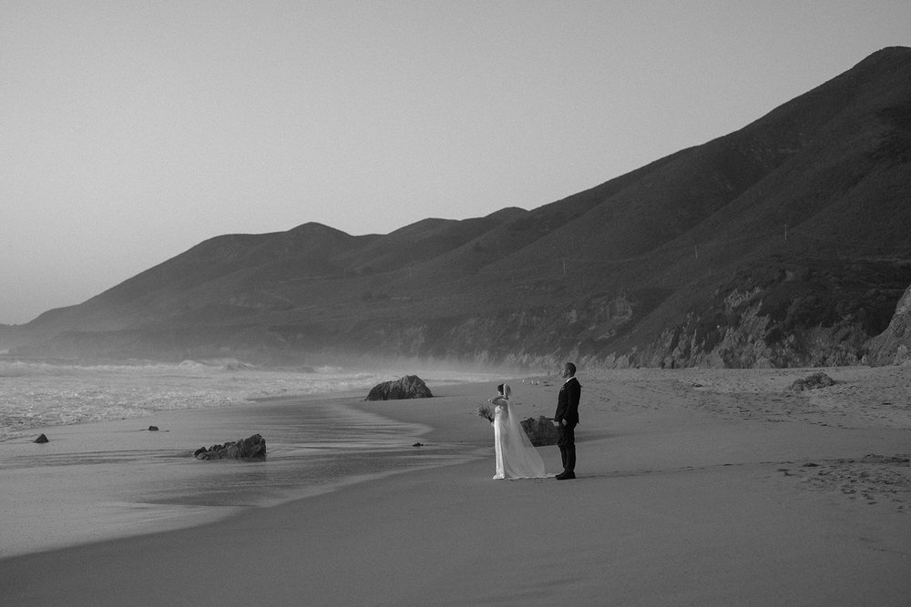 Bride and groom walking across the beach during their Big Sur elopement photos