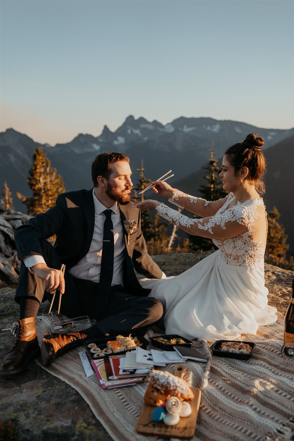 Bride feeds groom during elopement picnic at Mount Rainier National Park