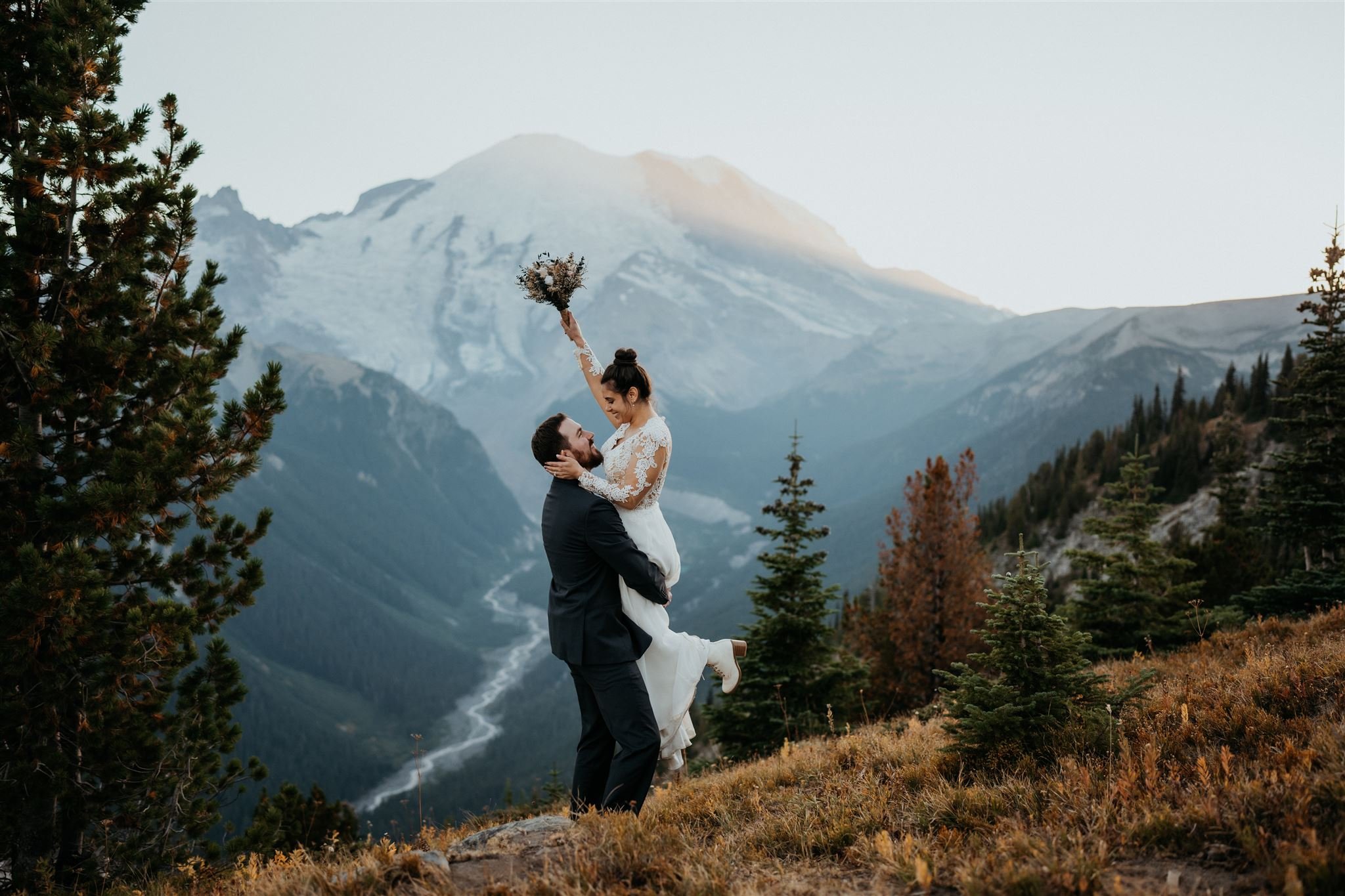 Groom lifts bride into the air during elopement at Mount Rainier