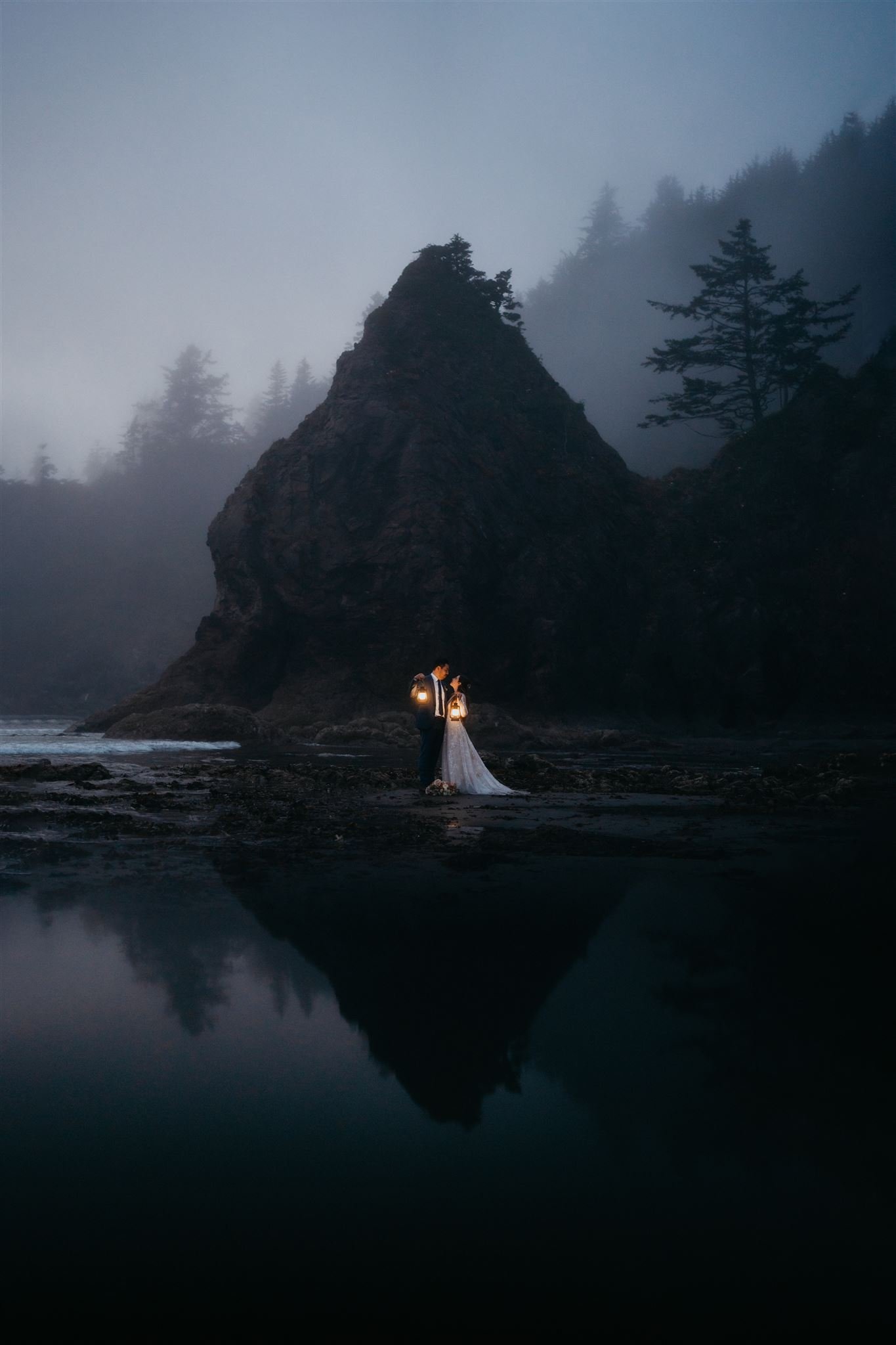 Bride and groom hold lanterns on the beach during their Olympic National Park elopement