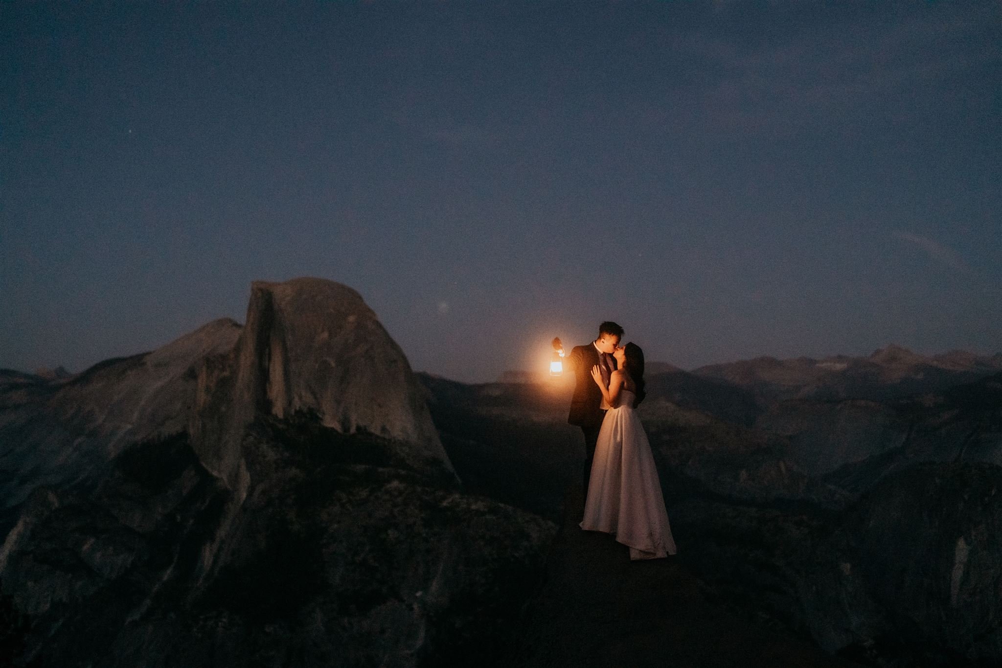 Bride and groom hold lanterns during blue hour elopement photos at Yosemite National Park