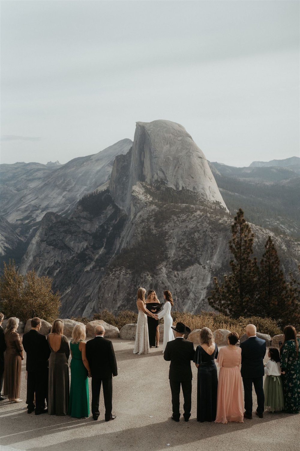 Two brides hold hands during their Yosemite elopement at Glacier Point