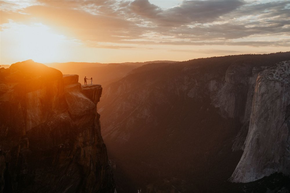 Bride and groom hold hands while walking around Taft Point at their Yosemite elopement