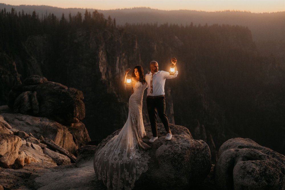Bride and groom hold lanterns at their sunset elopement at Taft Point