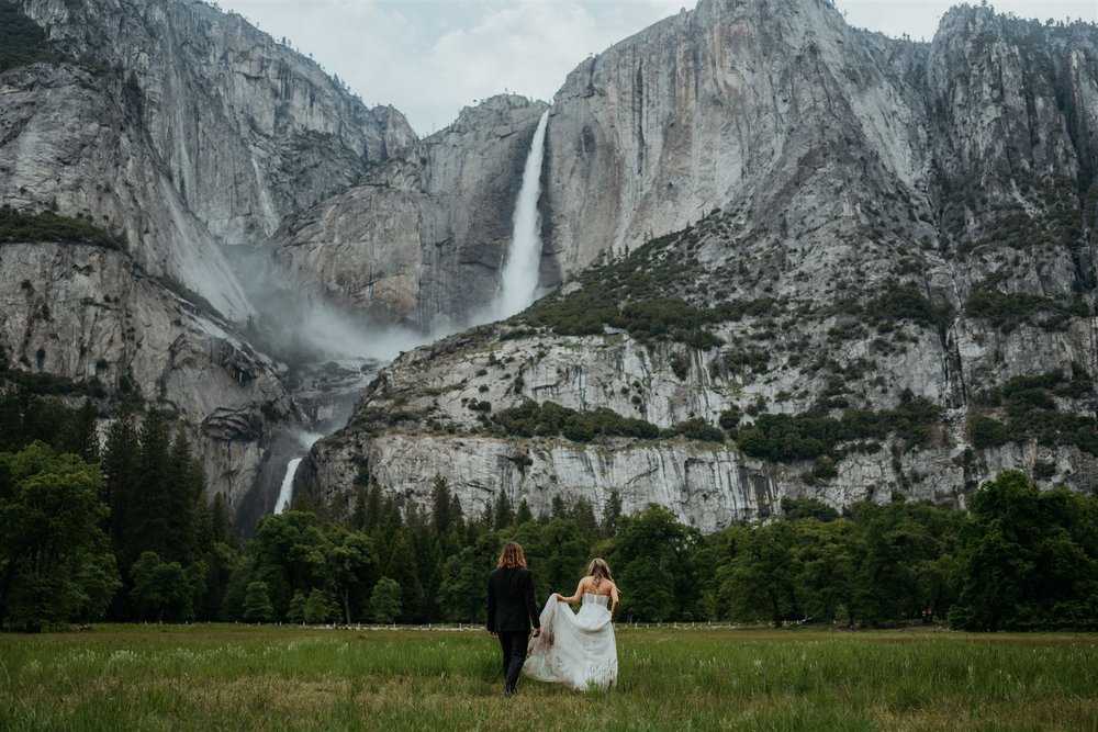 Bride and groom walk across the field at their Yosemite Falls elopement