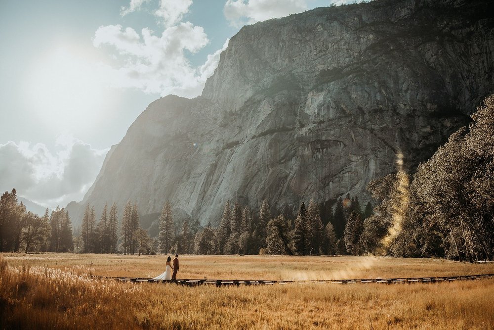 Bride and groom walk across El Capitan Meadow at their Yosemite elopement